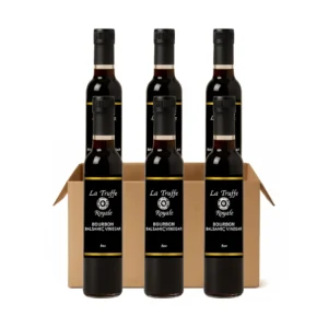 Case of La Truffe Royale bourbon balsamic vinegar bottles on white background.