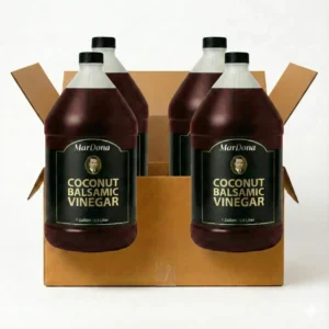 Wholesale case containing four 1-gallon jugs of MarDona Coconut Balsamic Vinegar in an open cardboard shipping box.